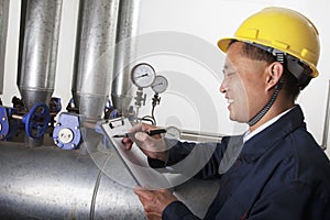 Smiling worker checking the oil pipeline equipment in a gas plant, Beijing, China