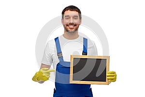 smiling worker or male cleaner showing chalkboard