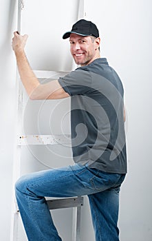 Smiling worker man hold a ladder on white background