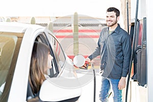 Smiling Worker Refueling Car At Gas Station