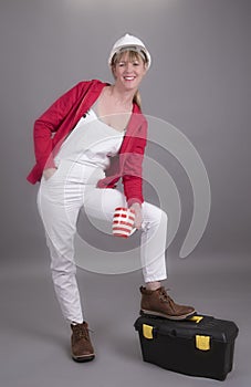 Smiling worker wearing a hardhat and holding a mug of tea