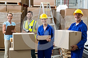 Smiling workers carrying boxes