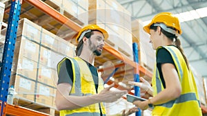 Smiling workers in distribution warehouse having a cheerful conversation