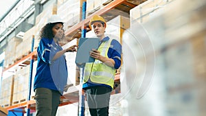 Smiling workers in distribution warehouse having a cheerful conversation