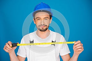 Smiling workman holding a tape measure