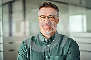Smiling 45 years old business man wearing glasses in office, headshot portrait.