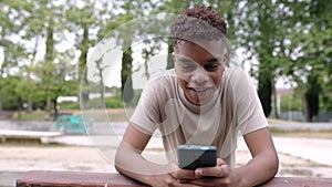 Smiling young adult hispanic american man using smart mobile phone outdoor