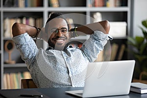 Smiling young african american businessman relaxing on chair.