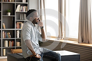 Smiling young african american businessman talking on smartphone.
