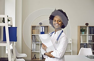 Smiling young african american doctor in uniform with paper in hand portrait