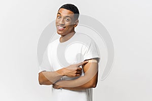 Smiling young African-American guy showing arm with band-aid after vaccine injection isolated on blue