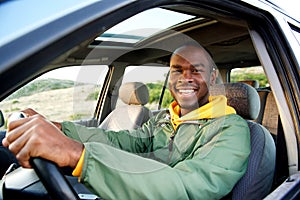 Smiling young african american man driving car