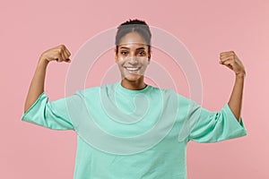 Smiling young african american woman girl in green sweatshirt posing isolated on pastel pink background studio portrait