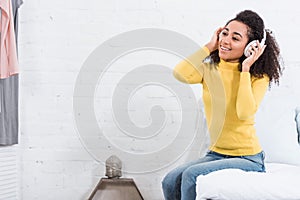 Smiling young african american woman listening music