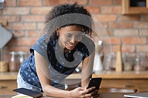 Smiling young african american woman using smartphone application.