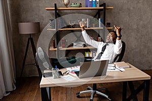 Smiling young african businessman relax while sitting at a table in the office