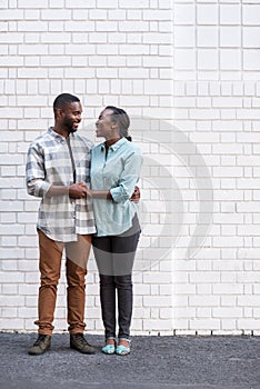 Smiling young African couple standing in the city together