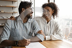 Happy black spouses support one another in signing contract photo