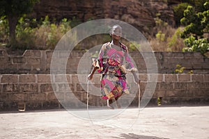 Smiling Young African Girl Warming Up With A Skipping Rope in The Backyard