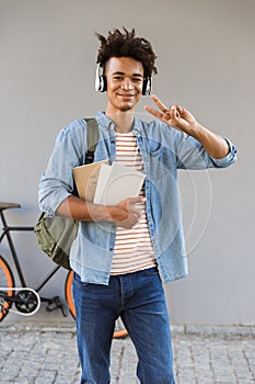 Smiling young african man with backpack outdoors