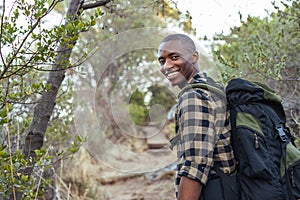 Smiling young African man hiking in the hills