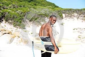 Smiling young african man with surfboard