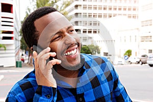 Smiling young african man talking on cellphone in the city