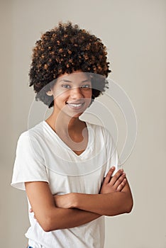 Smiling young African woman with an afro standing at home