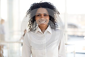 Smiling young african woman employee or intern in office portrai