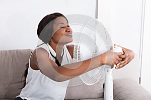 Woman Enjoying Breeze With Electric Fan photo