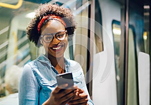 Smiling young African woman listening to music on her commute