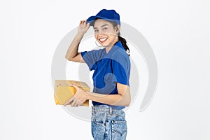 Smiling young Asian delivery woman in blue uniform holding package parcel box over white isolated background
