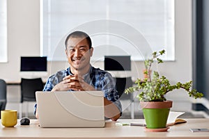 Smiling young Asian designer at work in a modern office