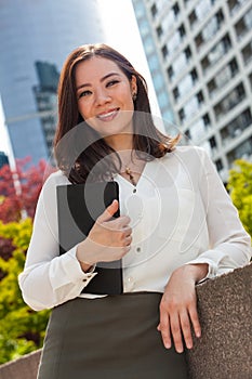 Smiling Young Asian Woman or Businesswoman in a City