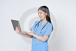 Smiling young asian woman doctor with stethoscope using laptop isolate on white background