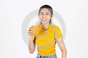 Smiling young Asian woman drinking orange juice over white isolated background. Lifestyle, Diet, Healthy and clean food concept