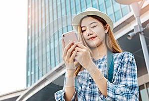 Smiling young Asian woman with shopping colour bags over mall background. using a smart phone shopping online  and smiling while