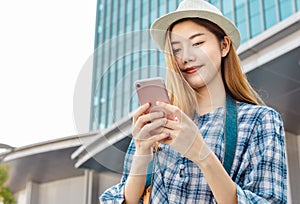 Smiling young Asian woman with shopping colour bags over mall background. using a smart phone shopping online  and smiling while