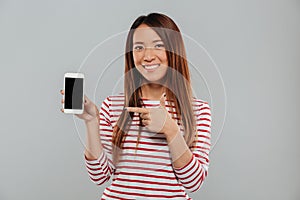 Smiling young asian woman showing display of phone photo