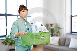 smiling young asian woman sorting plastic waste