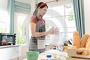 Smiling young asian woman work making sweet pie or pastry dough in kitchen