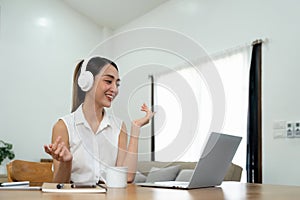 Smiling young asian woman working on laptop at home. Attractive asia female using computer remote studying, watching