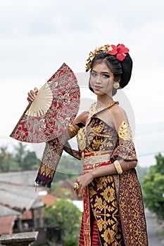 Smiling young Balinese girl with a fan