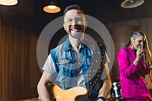 Smiling young bass guitarist during rehearsal