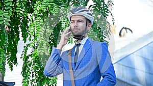 Smiling Young Bearded Businessman Outdoors Talking By Smartphone
