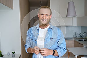 Smiling young man first time estate owner hold key to new home look at camera. photo