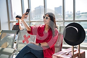 Smiling young beautiful Asian woman selfie in airport