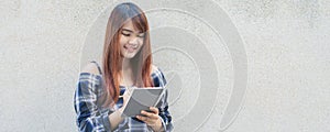 Smiling young beautiful asian women with book. Closeup brown head beautiful young woman pretty happy reading on concrete wall back