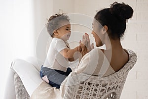 Happy biracial mother play with toddler baby