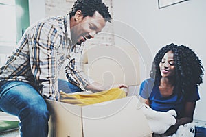 Smiling young black african couple moving boxes into new home together and making a successful life.Cheerful family